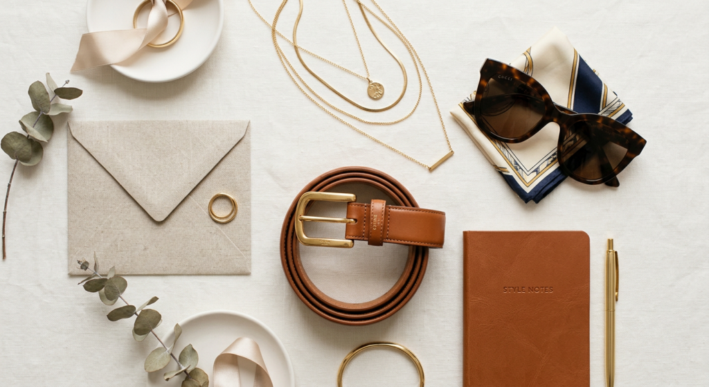 A professional editorial flat lay featuring a curated selection of stylish fashion accessories like
