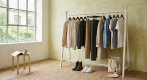 A minimalist, high-end editorial shot of a curated capsule wardrobe featuring neutral-toned garments